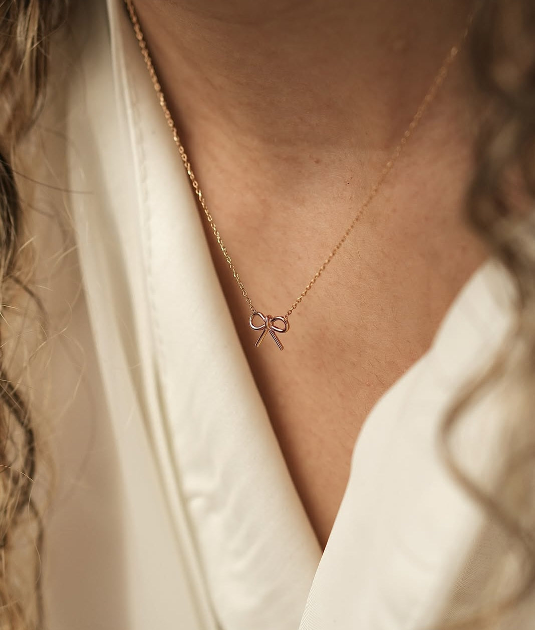 Model wearing elegant bow necklace with subtle shine