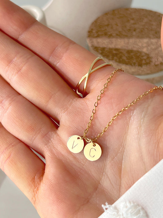 Model hand showing gold initial coin pendant 