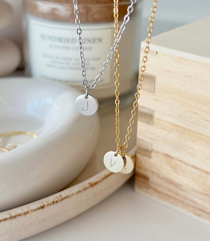 Product shoot of gold and silver initial coin pendant 