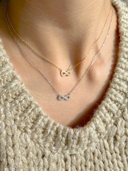 Model wearing layered infinity necklaces in gold and silver polish